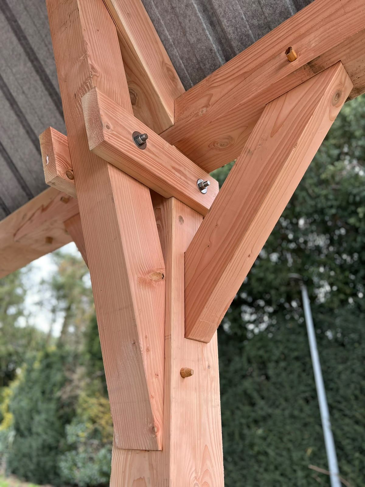 Detail van een douglas hoekverbinding met tapse schoor en doorgestoken bout