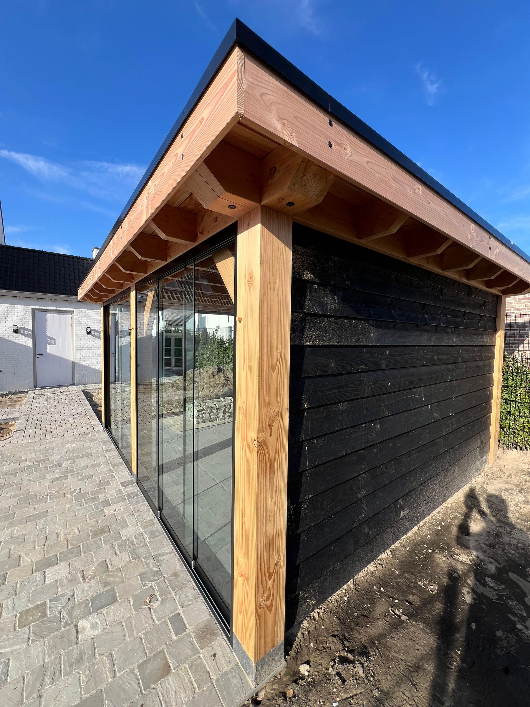 Tuinkamer met glazen wanden en douglas stijlen in de tuin