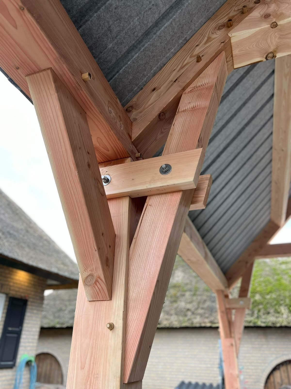 Detail van een houtverbinding met schoor en zichtbare bout
