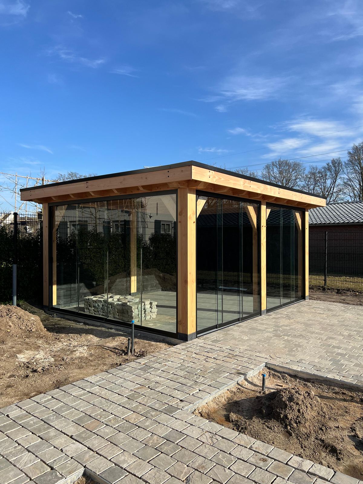 Tuinkamer met glazen schuifpui en zwarte gevelbekleding
